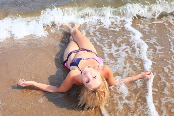Mulher bonita em biquíni banhos de sol à beira-mar — Fotografia de Stock