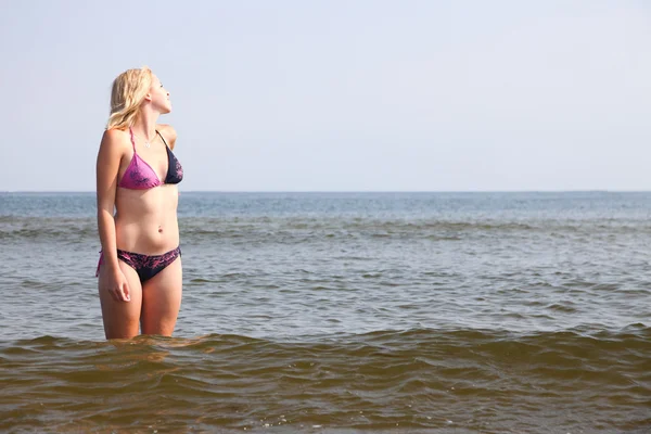 Hermosa mujer en bikini tomando el sol junto al mar — Foto de Stock