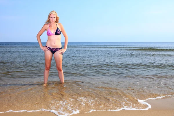 Vacker kvinna i bikini sola vid havet — Stockfoto