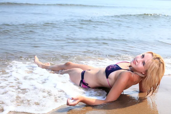 Schöne Frau im Bikini sonnt sich am Meer — Stockfoto