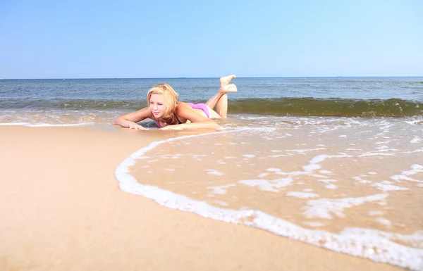 Vacker kvinna i bikini sola vid havet — Stockfoto