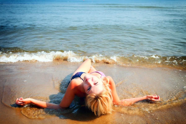 Piękna kobieta w bikini opalanie nad morzem — Zdjęcie stockowe