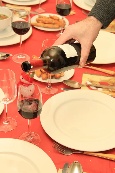 Homme versant du vin à la table de Noël — Photo