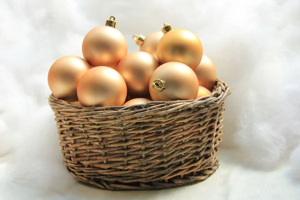 Gyllene christmas ornament i en flätad korg — Stockfoto