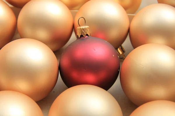 Red ornament on a pile of golden ornaments — Stock Photo, Image