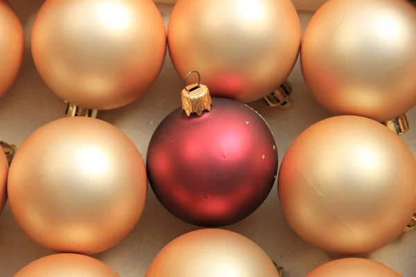 Rode sieraad op een stapel van gouden ornamenten — Stockfoto