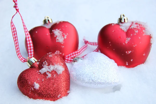 Röda och vita hjärtat ornament i snö — Stockfoto