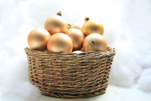 Golden Christmas ornaments in a wicker basket — Stock Photo, Image