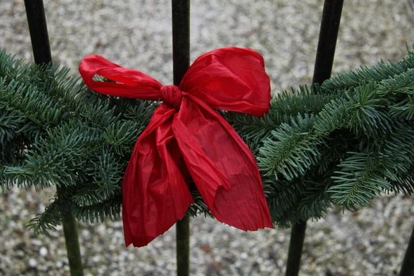 Arco vermelho em uma grinalda — Fotografia de Stock