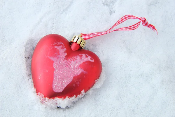 Heart shaped ornament in the snow Royalty Free Stock Photos