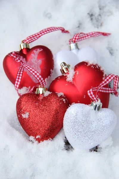 Enfeites de coração vermelho e branco na neve — Fotografia de Stock