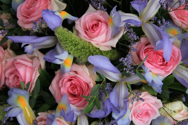 Синие ирисы и розовые розы в свадебной композиции — стоковое фото