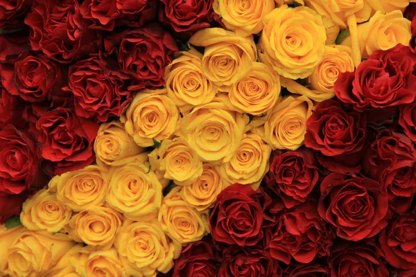 Röda och gula rosor i en bröllop arrangemang — Stockfoto