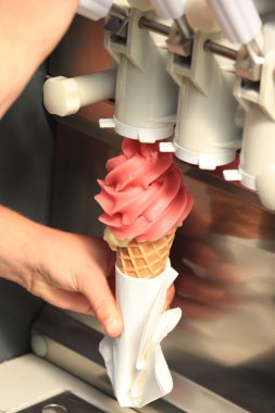 Woman holding a waffle cone under a machine with pink stawberry soft ice clipart