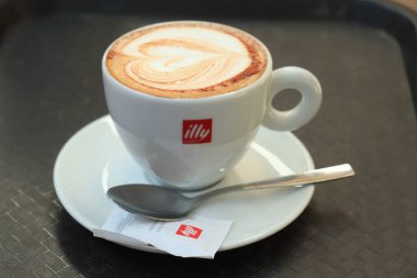 Barselona, İspanya - 29 Eylül 2019: Illy Cappuccino markalı bir kahve fincanında Illy şeker ve kalp çizimi sütlü sütlü latte sanatı olarak çizildi