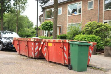 İnşaat alanının yakınındaki dolu çöp konteynırları, tadilat ya da bakım.