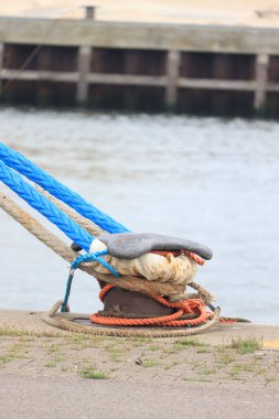 Limanda paslı bir gemi kazanı ve ip.