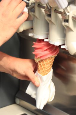 Woman holding a waffle cone under a machine with pink stawberry soft ice clipart