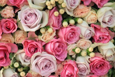 Büyük bir düğün süsü içinde pembe ve mor güller.