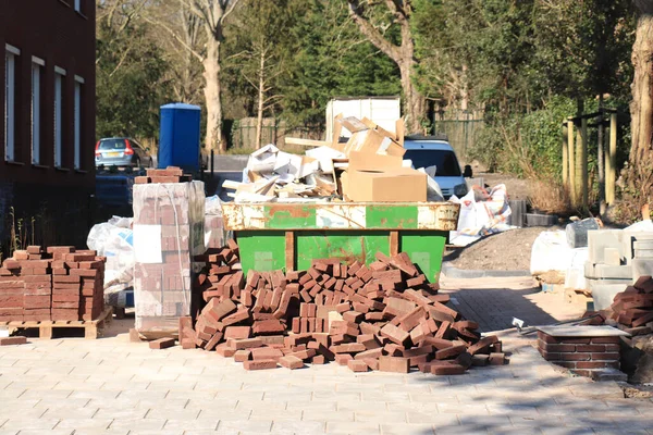 Beladene Müllcontainer Und Ein Haufen Ziegel Der Nähe Einer Baustelle — Stockfoto