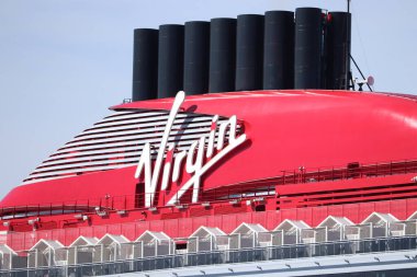 IJmuiden, Hollanda - 20 Nisan 2022: Valiant Lady yolcu gemisi, Virgin Voyages tarafından işletiliyor, gemi yapımcısı Fincantieri. Virgin Şirketi logosuna sahip kırmızı huninin ayrıntıları