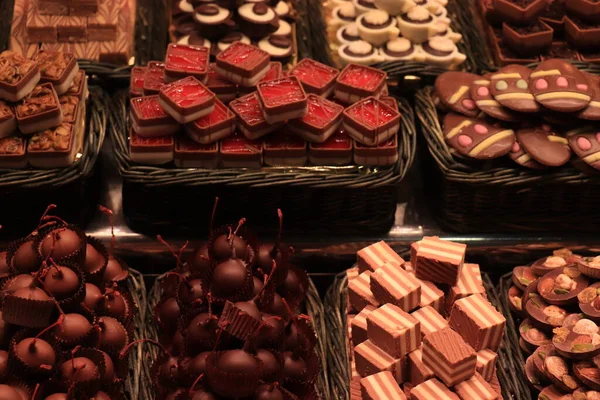 チョコレートは スペインのバルセロナの市場でナッツとチェリーと豪華なチョコレートのプラリネを浸した — ストック写真