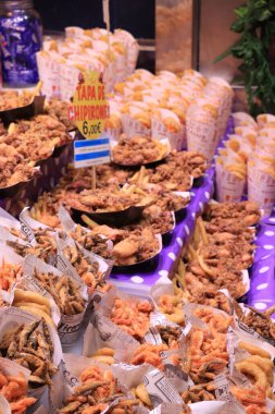 Barselona, İspanya - 30 Eylül 2019: La Boqueria Market 'te kızarmış balık. Çeşitli deniz ürünleri, balık kroket ve mürekkep balığı halkaları.