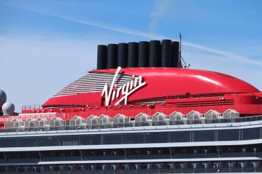IJmuiden, Hollanda - 20 Nisan 2022: Valiant Lady yolcu gemisi, Virgin Voyages tarafından işletiliyor, gemi yapımcısı Fincantieri. Virgin Şirketi logosuna sahip kırmızı huninin ayrıntıları