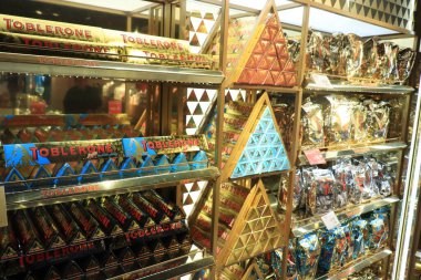 Amsterdam Schiphol Havaalanı, Hollanda - 24 Eylül 2019: Toblerone çikolatası, havaalanı alışveriş alanında tanıtım sergisi. Farklı tatları temsil eden çeşitli renkler.