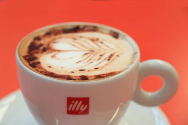 Barselona, İspanya - 29 Eylül 2019: Illy Cappuccino markalı bir kahve fincanında Illy şeker ve kalp çizimi sütlü sütlü latte sanatı olarak çizildi