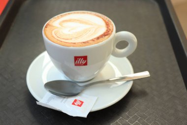 Barselona, İspanya - 29 Eylül 2019: Illy Cappuccino markalı bir kahve fincanında Illy şeker ve kalp çizimi sütlü sütlü latte sanatı olarak çizildi