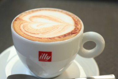 Barselona, İspanya - 29 Eylül 2019: Illy Cappuccino markalı bir kahve fincanında Illy şeker ve kalp çizimi sütlü sütlü latte sanatı olarak çizildi