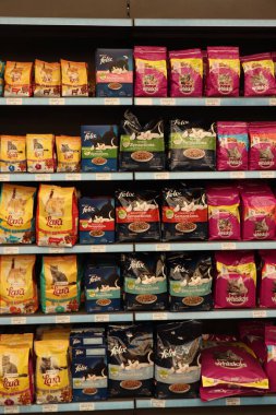 Assen, Hollanda - 10 Mayıs 2022: Evcil hayvan dükkanında kedi maması bölümü. Renkli çantalar ve çeşitli markalar.