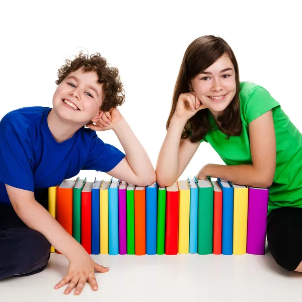 Дети за стопкой книг изолированы на белом фоне — стоковое фото