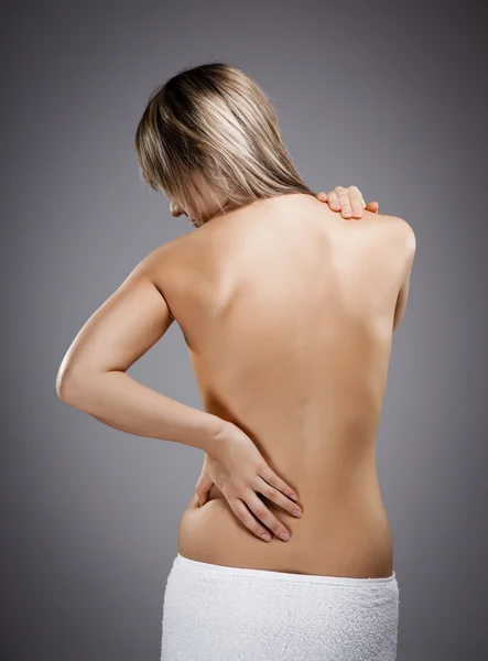Mulher massageando dor nas costas — Fotografia de Stock
