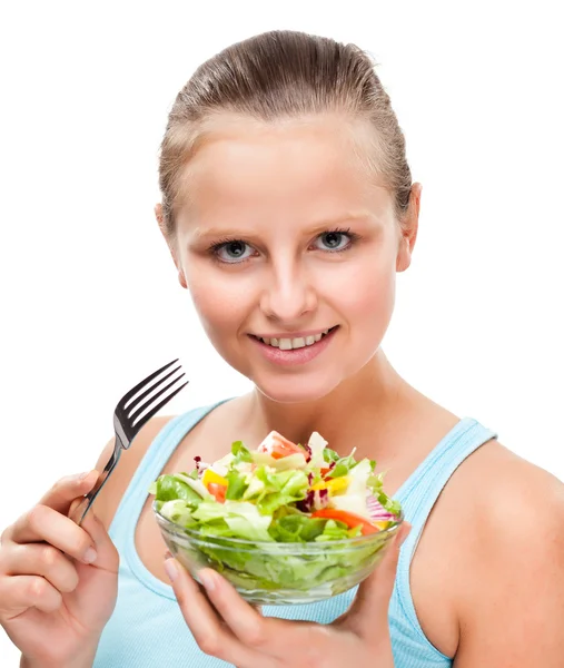 Jovem mulher comendo salada de legumes isolada em branco — Fotografia de Stock