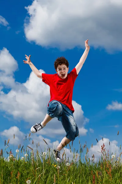 Niño saltando, corriendo contra el cielo azul — Foto de Stock