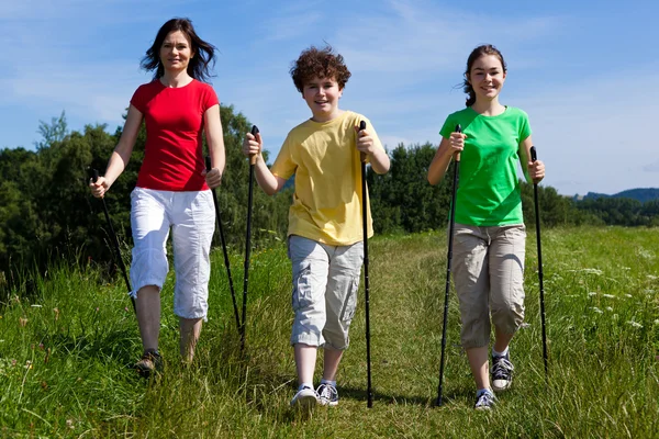 Nordic walking - familia activa caminando al aire libre —  Fotos de Stock