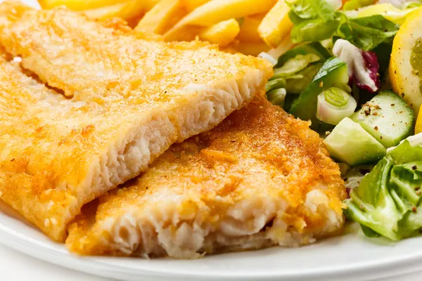 Рыбное блюдо - жареное филе рыбы, картофель фри с овощами — стоковое фото
