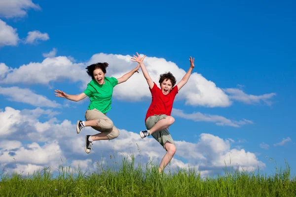 Girl and boy running, jumping outdoor — Stock Photo, Image