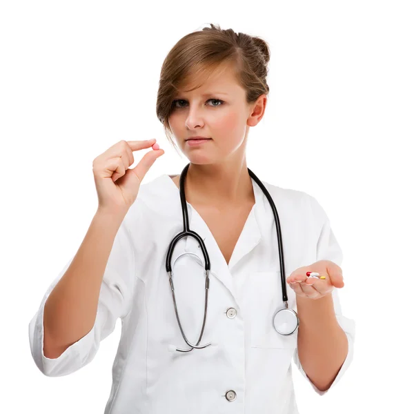 Ung kvinnlig läkare håller piller isolerad på vit bakgrund — Stockfoto