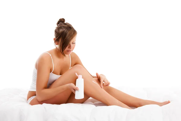 Donna massaggiare gambe seduta su sfondo bianco — Foto Stock