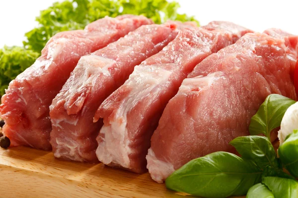 Carne de porc brut pe placa de tăiere și legume — Fotografie, imagine de stoc