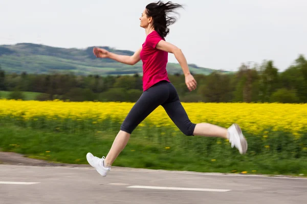 Žena běh, skákání venkovní — Stock fotografie