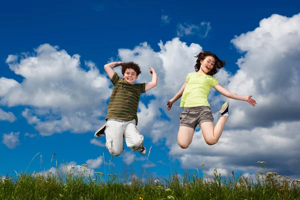 Girl and boy running, jumping outdoor — Stock Photo, Image