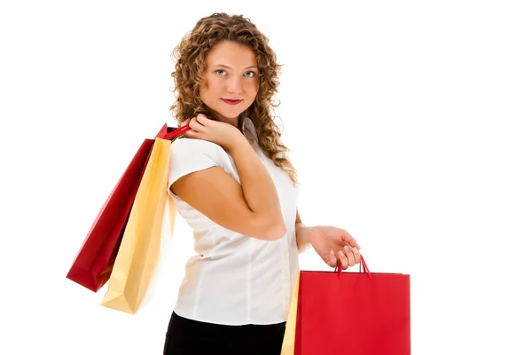Mladá žena drží nákupní tašky izolovaných na bílém pozadí — Stock fotografie