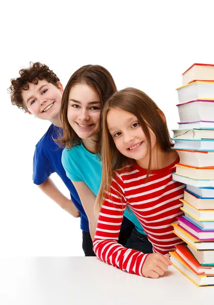 Studenten blicken hinter Stapel von Büchern auf weiß Stockbild