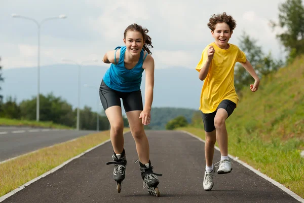 Aktív fiatalok - görkorcsolya, futás Stock Kép