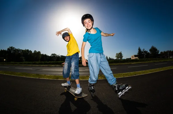 Активная молодежь - роллеры, скейтбордисты — стоковое фото