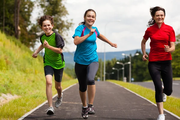 Healthy lifestyle - mother and kids running outdoor — Stock Photo, Image